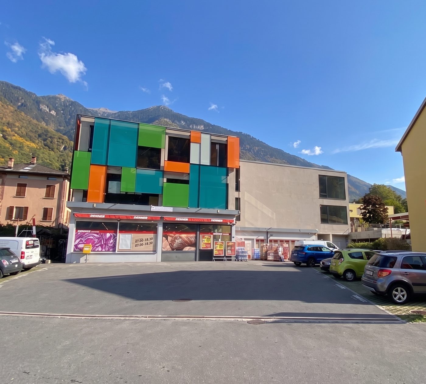 Il Centro Opti a Lumino: la palazzina con la facciata verde, turchese e arancione dove apre THI LAND, sopra il supermercato Denner