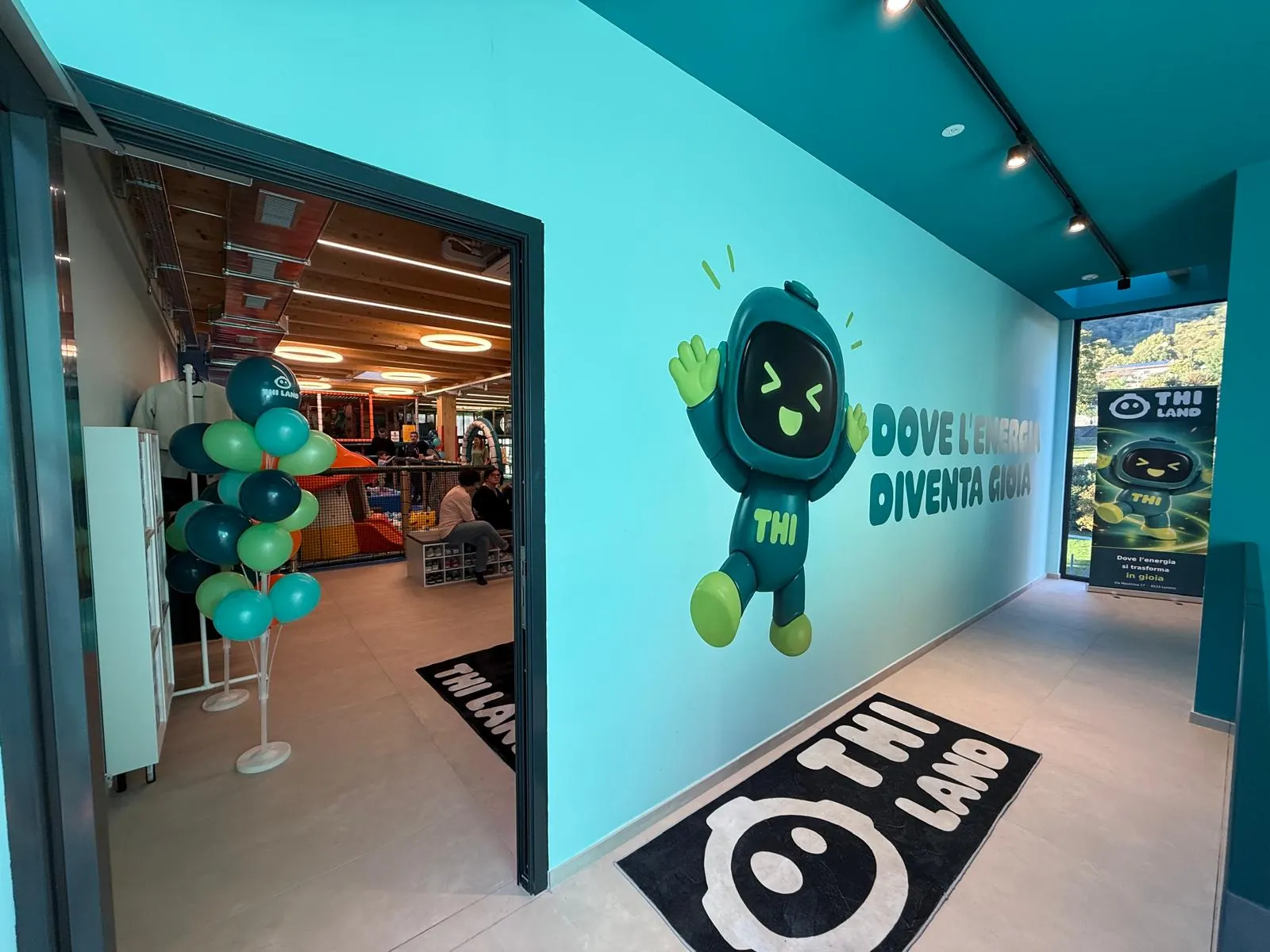Il corridoio d'ingresso con Thi, la mascotte, e la scritta Dove l'energia diventa gioia