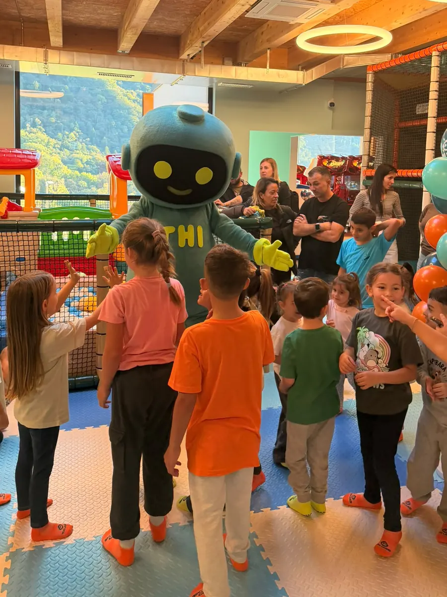 I bambini intorno a Thi, la mascotte, nella sala del parco