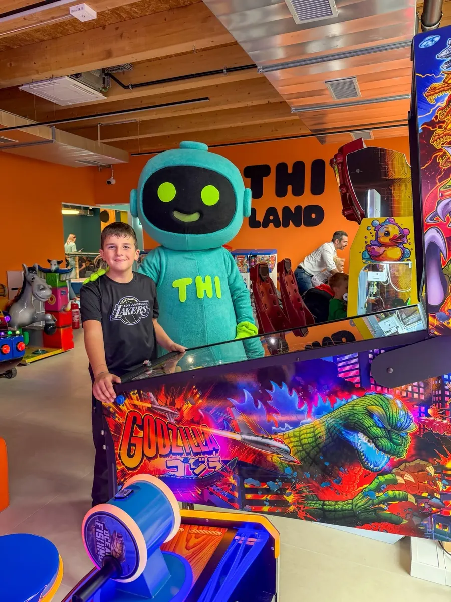 Un bambino al flipper con Thi, la mascotte, nella sala giochi