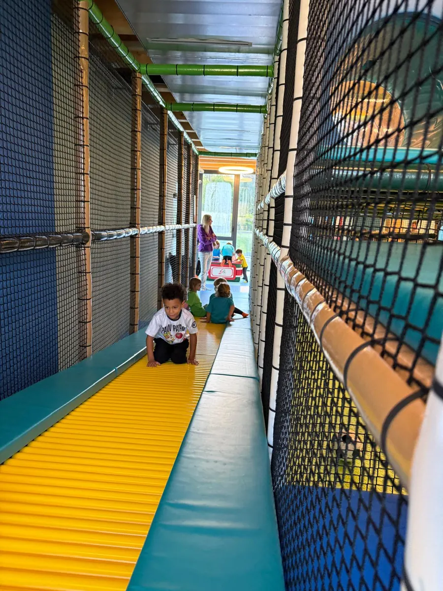 Un bambino scende dallo scivolo a rulli giallo dentro il percorso