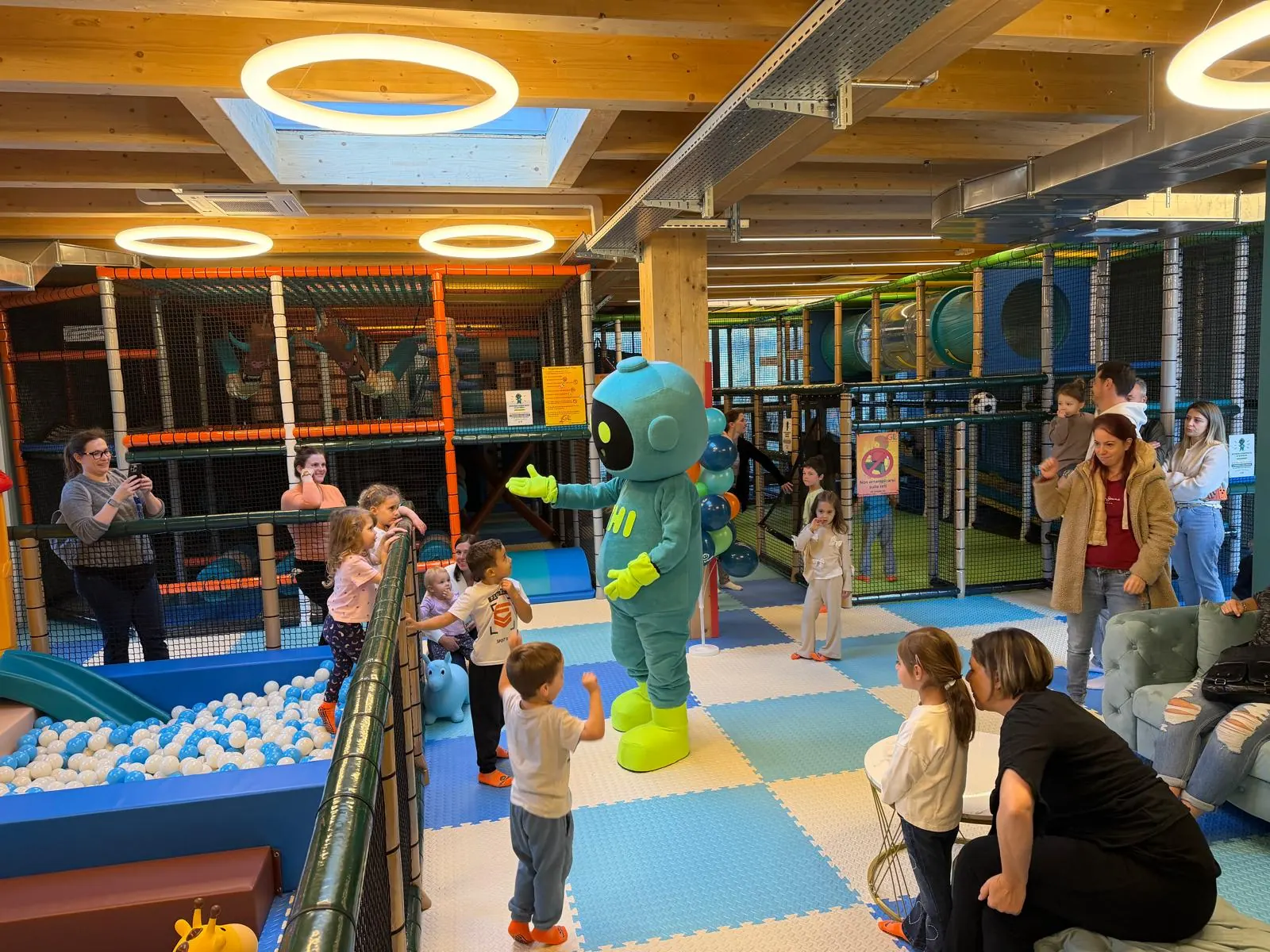 La sala principale di THI LAND: la mascotte THI gioca con i bambini accanto alla vasca con le palline e ai percorsi a più piani